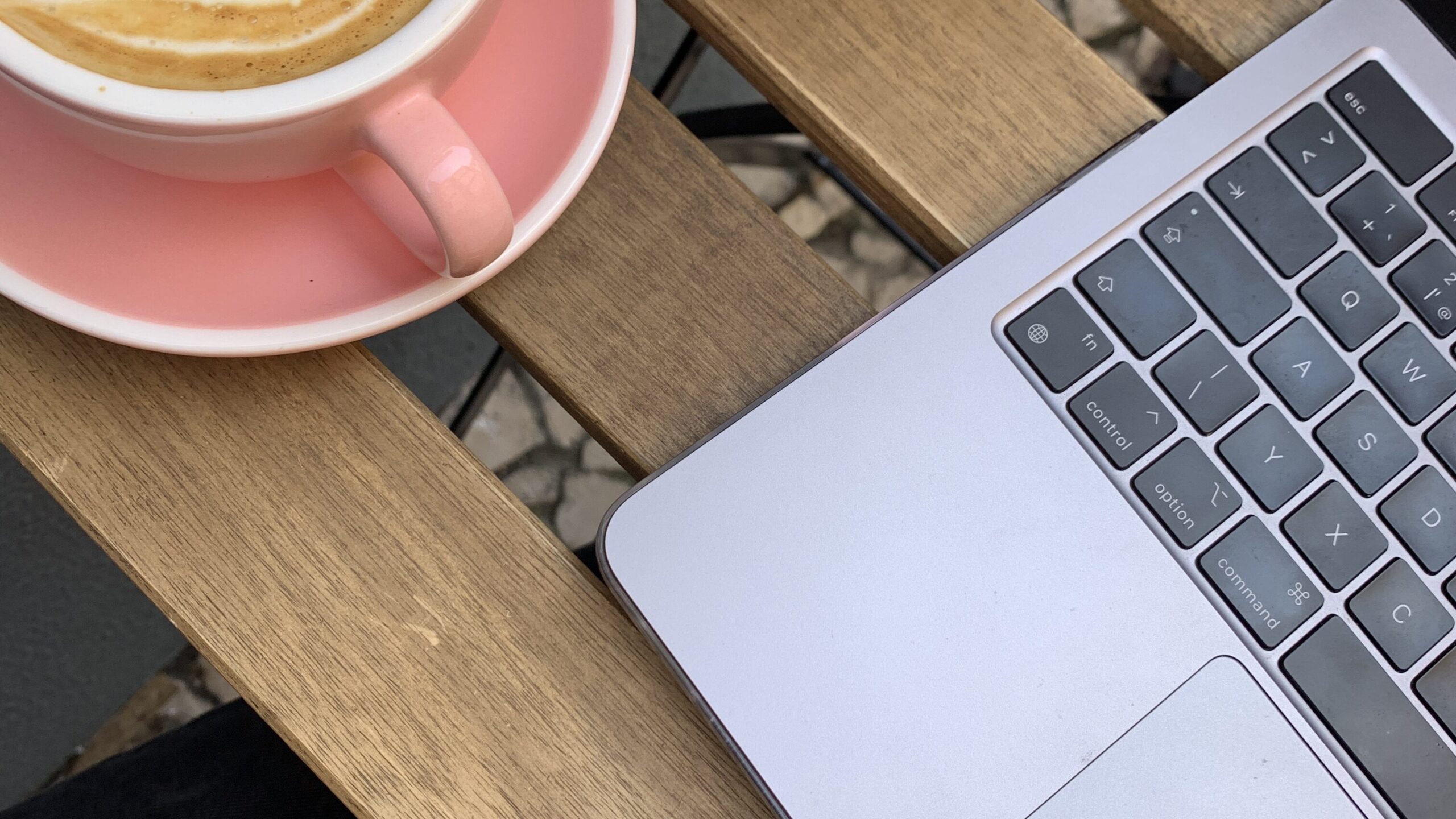 Macbook computer with pink coffee on a wooden bench, teaching bloggers what a URL is in their content | The Comma Mama Co.