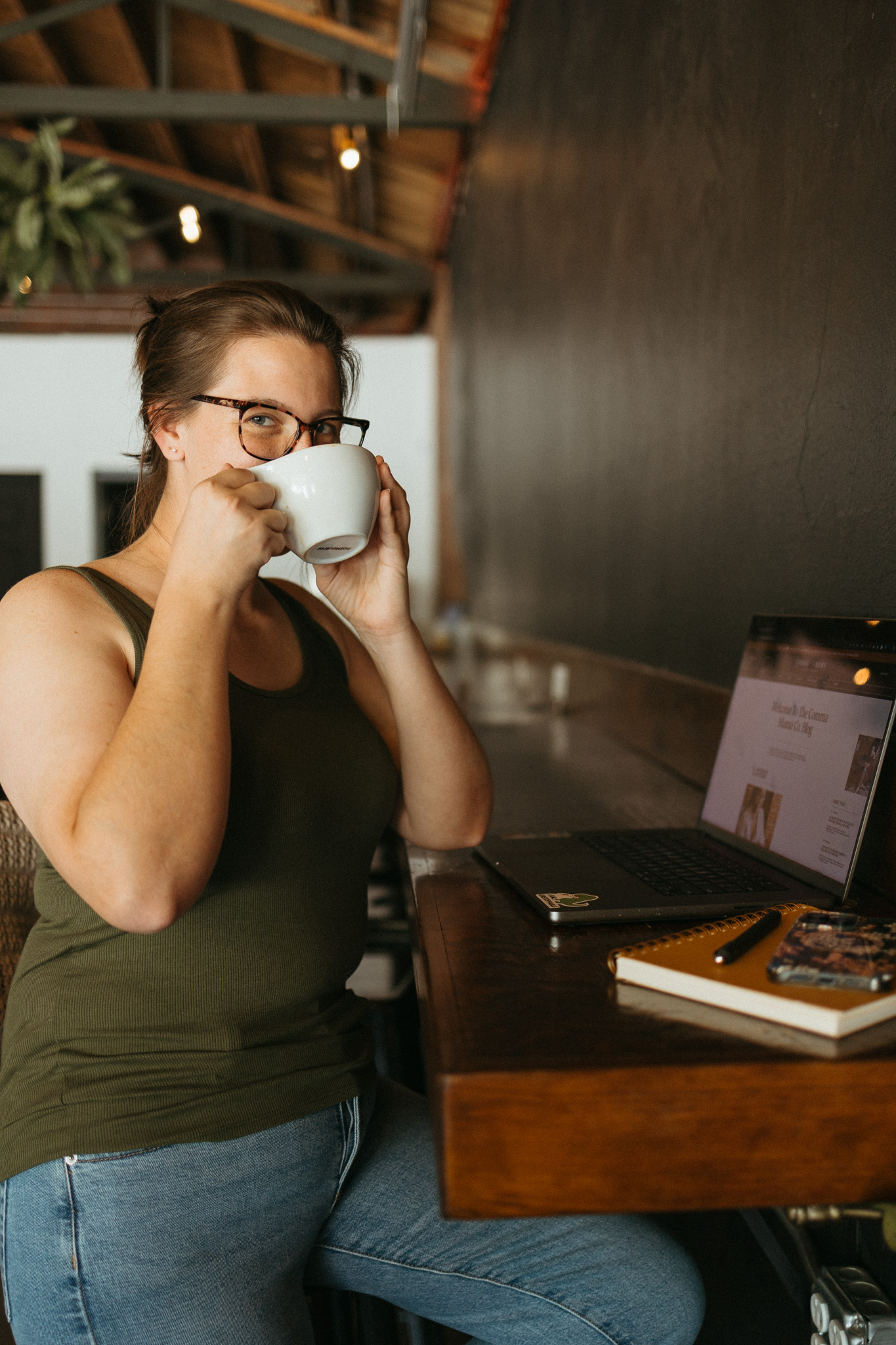 SEO strategist and blog content marketer breaking down email marketing myths for small business owners while sitting at a local coffee shop sipping chai next to her laptop computer