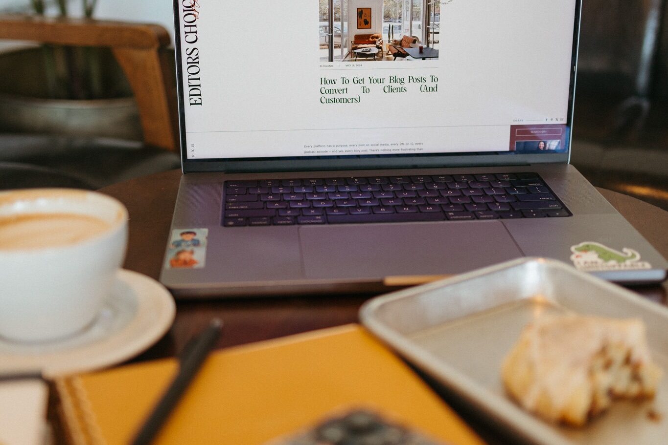 Computer open on a cafe table to a blog on how to blog and increase blog conversions for parenting professionals